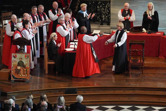 Attendees applaud Sarah Mullally (R) at the 'Confirmation of Election' ceremony to legally confirm her position as the new Archbishop of Canterbury, at St Paul’s Cathedral in London on January 28, 2026. Sarah Mullally, a former nurse, was named to become the first female Archbishop of Canterbury last October, pledging to improve safety at the Church of England following an abuse scandal that ousted her predecessor. (Photo by Gareth Fuller / POOL / AFP)