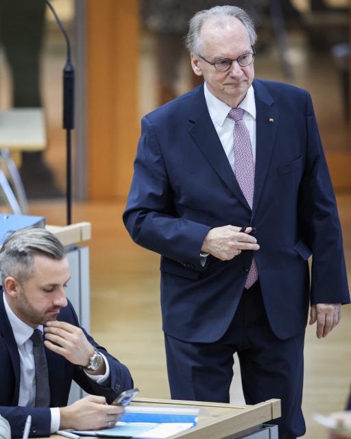 Saxony-Anhalt's outgoing State Premier Reiner Haseloff (R) walks past the far-right Alternative for Germany (AfD) top candidate Ulrich Siegmund at Saxony-Anhalt's State Parliament, on January 28, 2026 in Magdeburg, eastern Germany, prior to the election of Saxony-Anhalt's new regional leader. After roughly 15 years in office, Saxony-Anhalt's outgoing State Premier Reiner Haseloff  will not run in Saxony-Anhalt's state elections scheduled on September 6, 2026. (Photo by RONNY HARTMANN / AFP)