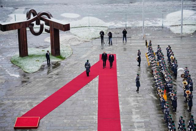 German Chancellor Friedrich Merz and Romanian Prime Minister Ilie Bolojan review the honor guard during a welcoming ceremony at the chancellery in Berlin, on Jannuary 28, 2026. (Photo by Ebrahim Noroozi / POOL / AFP)