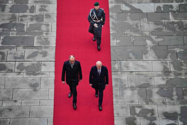 German Chancellor Friedrich Merz and Romanian Prime Minister Ilie Bolojan review the honor guard during a welcoming ceremony at the chancellery in Berlin, on Jannuary 28, 2026. (Photo by Ebrahim Noroozi / POOL / AFP)
