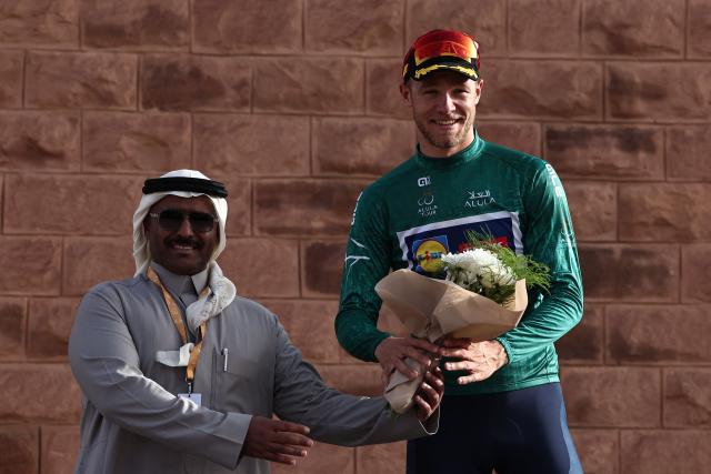 Lidl-Trek cycling team's Italian rider Jonathan Milan (R) celebrates on the podium after winning the second stage of the AlUla Tour cycling race, 152km from AlManshiyah Train Station to AlManshiyah Train Station on January 28, 2026. (Photo by Anne-Christine POUJOULAT / AFP)