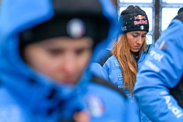 Sofia Goggia and others members of the Italy's alpine skiing team taking part in the World Cup races in Crans Montana, stand in front of the bar "Le Constellation" to pay tribute to the victims of the fire that ripped through the venue on New Year's Eve celebrations, in the Alpine ski resort of Crans-Montana on January 28, 2026. The fire on January 1 at the bar "Le Constellation" left 40 people dead -- including nine French and six Italian nationals -- and injured 116 others, most of them teenagers. (Photo by Fabrice COFFRINI / AFP)