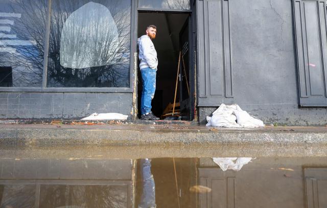 A person standsin the doorway of a flood-damaged shop after the River Slaney burst its banks during Strom Chandra, in Enniscorthy, near Wexford, south east Ireland on January 28, 2026. (Photo by Paul Faith / AFP)