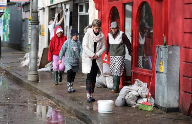 People work to clear flood water and damaged items from shops after the River Slaney burst its banks during Storm Chandra, in Enniscorthy, near Wexford, south east Ireland on January 28, 2026. (Photo by Paul Faith / AFP)