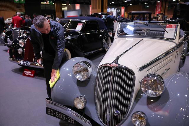 A man cleans a vintage 1938 Delahaye 135M Cabriolet displayed at the 50th edition of the Retromobile exhibition, the international classic cars fair at Paris Expo Porte de Versailles in Paris on January 28, 2026 a day before its auction by Gooding Christies. (Photo by Dimitar DILKOFF / AFP)