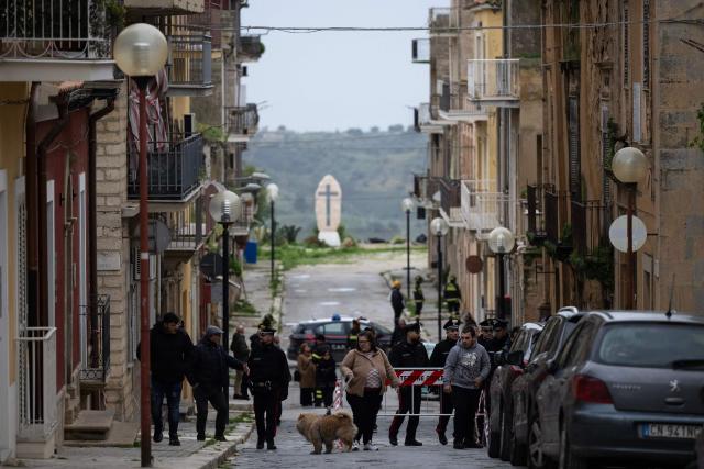 Inhabitants leave their homes due to a landslide in the city centre of Niscemi on Januray 28, 2026. More than 1,000 people were evacuated in Sicily after a four-kilometre (2.5-mile) section of cliff crumbled during a storm, leaving houses perched perilously on the edge, authorities said on January 26, 2026. (Photo by MARCO BERTORELLO / AFP)