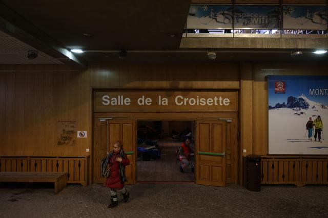 A woman walks out of the emergency reception room for fire evacuees after a fire that broke out the evening before at the five-star Grandes Alpes hotel in the upscale French Alpine ski resort of Courchevel, southeastern France, forcing the evacuation of 83 occupants, on January 28, 2026. In the afternoon of January 28, 2026, firefighters contained the intense fire that had broken out the previous day in a five-star hotel in the Courchevel ski resort, slightly injuring six of them. (Photo by Alex MARTIN / AFP)