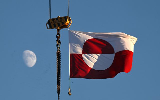 A flag of Greenland hangs from a crane in the city of Nuuk, western Greenland, on January 28, 2026. (Photo by Ina FASSBENDER / AFP)