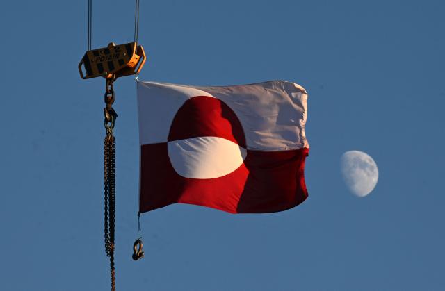 A flag of Greenland hangs from a crane in the city of Nuuk, western Greenland, on January 28, 2026. (Photo by Ina FASSBENDER / AFP)