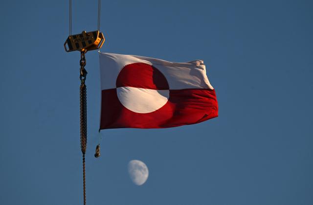 A flag of Greenland hangs from a crane in the city of Nuuk, western Greenland, on January 28, 2026. (Photo by Ina FASSBENDER / AFP)
