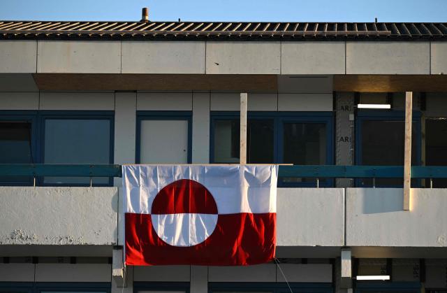 A flag of Greenland hangs at a balcony of an apartment in the city of Nuuk, western Greenland, on January 28, 2026. (Photo by Ina FASSBENDER / AFP)