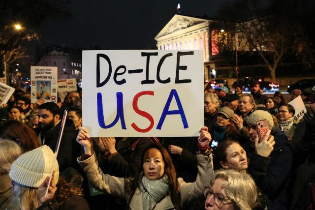 A protester holds a placard as they take part in a rally against Donald Trump's policies in front of the National Assembly in Paris on January 28, 2026. On January 24, federal agents shot and killed Alex Pretti, a 37-year-old ICU nurse, while scuffling with him on an icy roadway in Minneapolis, less than three weeks after an immigration officer fired on Renee Good, also 37, killing her in her car. The killings capped months of escalating violence in which masked, unidentified and heavily armed ICE and border patrol agents have grabbed people they accuse of violations off the streets. (Photo by Dimitar DILKOFF / AFP)