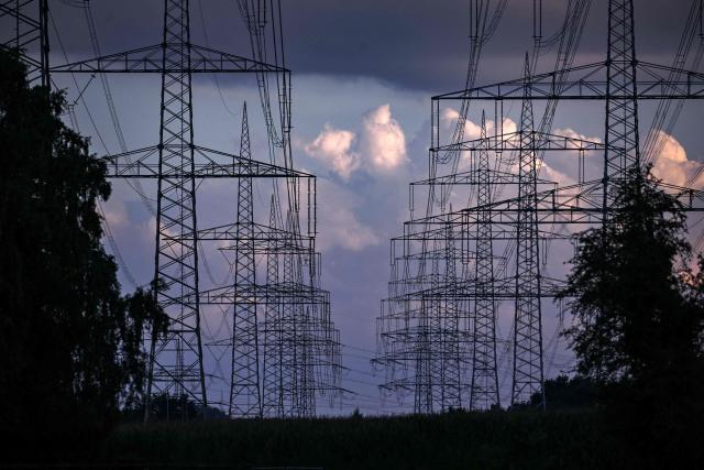 (FILES) A partial view the taken at evening dawn shows power lines and pylons near the Marl Chemical Park that is run by Evonik Industries AG, near Marl, western Germany on August 15, 2023. Germany plans to better protect its critical infrastructure with a new law on January 29, 2026 as surging tensions with Russia stoke fears of sabotage attacks and other national security threats. Parliament will vote on legislation requiring power utilities, water companies and even some supermarket chains to reduce their vulnerability to terrorism, industrial accidents, natural disasters and public health emergencies. (Photo by Ina FASSBENDER / AFP)