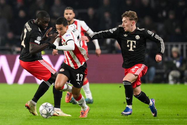 PSV Eindhoven's Brazilian defender #17 Mauro Junior (C) fights for the ball with Bayern Munich's French defender #02 Dayot Upamecano (L) and Bayern Munich's German midfielder #42 Lennart Karl during the UEFA Champions League league phase day 8 football match between PSV Eindhoven and Bayern Munich at Philips Stadion in Eindhoven on January 28, 2026. (Photo by JOHN THYS / AFP)