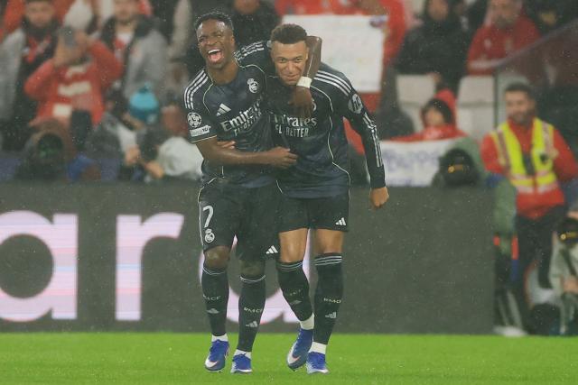Real Madrid's French forward #10 Kylian Mbappe (R) celebrates with teammate Brazilian forward #07 Vinicius Junior (L) after scoring his team's first goal during the UEFA Champions League league phase day 8 football match between SL Benfica and Real Madrid CF at Estadio da Luz in Lisbon on January 28, 2026. (Photo by PATRICIA DE MELO MOREIRA / AFP)