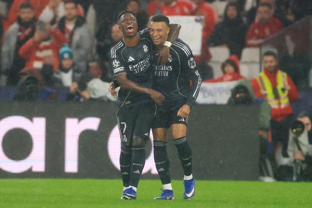 Real Madrid's French forward #10 Kylian Mbappe (R) celebrates with teammate Brazilian forward #07 Vinicius Junior (L) after scoring his team's first goal during the UEFA Champions League league phase day 8 football match between SL Benfica and Real Madrid CF at Estadio da Luz in Lisbon on January 28, 2026. (Photo by PATRICIA DE MELO MOREIRA / AFP)