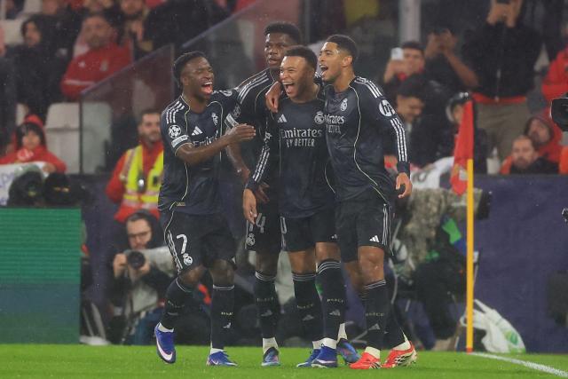 Real Madrid's French forward #10 Kylian Mbappe celebrates scoring his team's first goal with teammates Brazilian forward #07 Vinicius Junior, French midfielder #14 Aurelien Tchouameni and English midfielder #05 Jude Bellingham during the UEFA Champions League league phase day 8 football match between SL Benfica and Real Madrid CF at Estadio da Luz in Lisbon on January 28, 2026. (Photo by PATRICIA DE MELO MOREIRA / AFP)