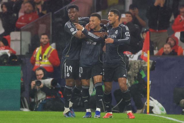 Real Madrid's French forward #10 Kylian Mbappe (C) celebrates scoring his team's first goal with teammates French midfielder #14 Aurelien Tchouameni and English midfielder #05 Jude Bellingham during the UEFA Champions League league phase day 8 football match between SL Benfica and Real Madrid CF at Estadio da Luz in Lisbon on January 28, 2026. (Photo by PATRICIA DE MELO MOREIRA / AFP)