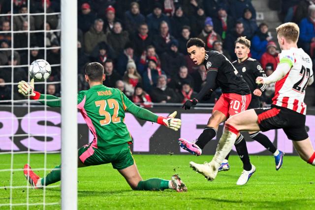 Bayern Munich's German midfielder #10 Jamal Musiala shoots and scores his team's first goal during the UEFA Champions League league phase day 8 football match between PSV Eindhoven and Bayern Munich at Philips Stadion in Eindhoven on January 28, 2026. (Photo by JOHN THYS / AFP)