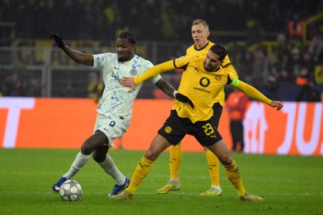 Inter Milan's French forward #9 Marcus Thuram (L) and Dortmund's German midfielder #23 Emre Can vie for the ball during the UEFA Champions League league phase - day 8 football match between BVB Borussia Dortmund and Inter Milan in Dortmund, western Germany, on January 28, 2026. (Photo by Sascha Schuermann / AFP)