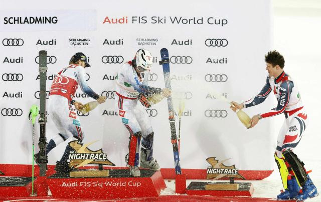 (L-R) Second placed Norway's Atle Lie Mcgrath, first placed Norway's Henrik Kristoffersen and third places France's Clement Noel celebrate on the podium after winning the second run of the men's Slalom event of FIS Alpine Skiing World Cup in Schladming, Austria, on January 28, 2026. (Photo by ERWIN SCHERIAU / APA / AFP) / Austria OUT