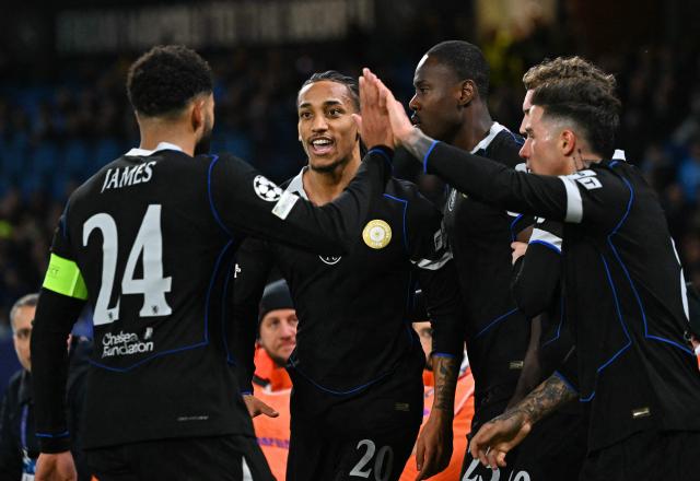 Chelsea's Brazilian striker #20 Joao Pedro celebrates with teammates after scoring his team's second goal during the UEFA Champions League - league phase day 8 football match between Napoli and Chelsea at the Diego Armando Maradona stadium in Naples on January 28, 2026. (Photo by Andreas SOLARO / AFP)