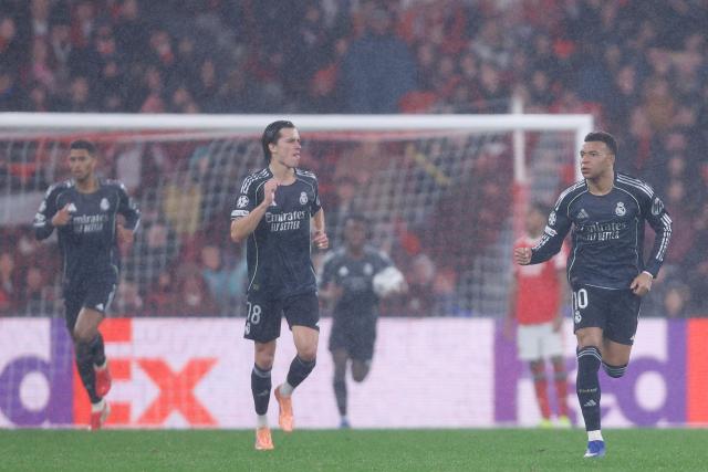 Real Madrid's French forward #10 Kylian Mbappe (R) celebrates scoring his team's second goal during the UEFA Champions League league phase day 8 football match between SL Benfica and Real Madrid CF at Estadio da Luz in Lisbon on January 28, 2026. (Photo by FILIPE AMORIM / AFP)