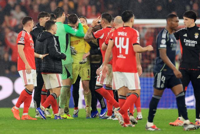 Real Madrid's Belgian goalkeeper #01 Thibaut Courtois hugs Benfica's Ukrainian goalkeeper #01 Anatoliy Trubin (C) at the end of the UEFA Champions League league phase day 8 football match between SL Benfica and Real Madrid CF at Estadio da Luz in Lisbon on January 28, 2026. (Photo by PATRICIA DE MELO MOREIRA / AFP)