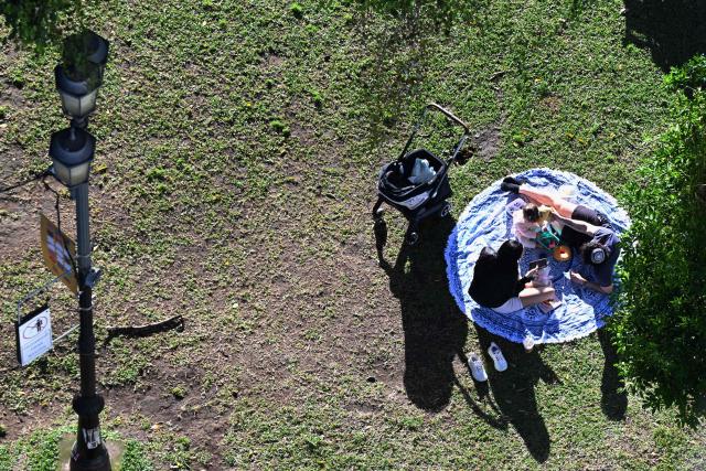 A family rests at the France Square in San Jose on 28 January 2026. Right-wing politician Laura Fernandez appears set to win Costa Rica's presidential election in the first round, according to two opinion polls published on January 21. (Photo by Marvin RECINOS / AFP)