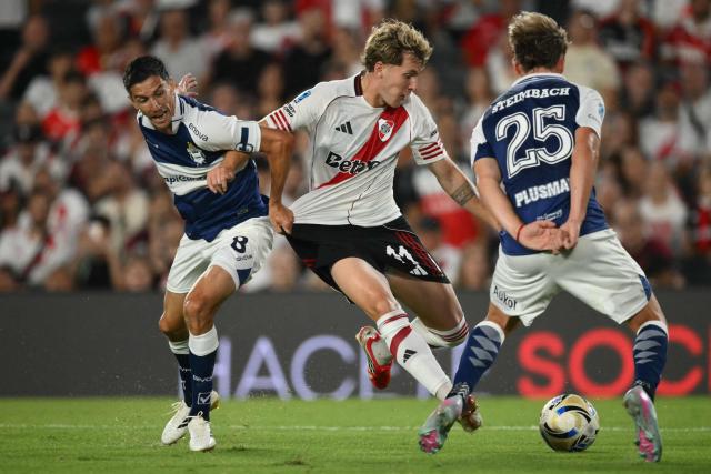 Gimnasia y Esgrima La Plata's midfielder #08 Igancio Fernandez and midfielder #25 Alexis Steimbach fight for the ball with River Plate's forward #11 Facundo Colidio during the Argentine Professional Football League 2026 Apertura Tournament match between River Plate and Gimnasia y Esgrima La Plata at the Mas Monumental Stadium in Buenos Aires on January 28, 2026. (Photo by Luis ROBAYO / AFP)