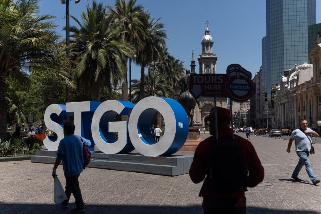 People walk in Santiago's Plaza de Armas on January 28, 2026. Chile has recorded its lowest birth rate ever, with less than one child per woman, placing it among the countries with the lowest number of births in the world, according to data presented on January 28 by the National Institute of Statistics (INE). (Photo by Raul BRAVO / AFP)