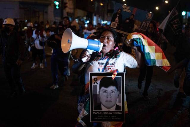 A demonstrator holds a picture of a victim as she takes part in a protest march called by Generation Z demanding the resignation of President Jeri in Lima on January 28, 2026. Peru's interim president, Jose Jeri, said on January 21 that he is the victim of a plot to force his resignation, in an appearance before a congressional committee investigating him for alleged influence peddling over a secret meeting with a Chinese businessman. (Photo by Ernesto BENAVIDES / AFP)