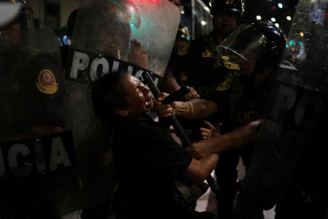 TOPSHOT - A demonstrator clashes with a riot police officer during a protest march called by Generation Z demanding the resignation of President Jeri in Lima on January 28, 2026. Peru's interim president, Jose Jeri, said on January 21 that he is the victim of a plot to force his resignation, in an appearance before a congressional committee investigating him for alleged influence peddling over a secret meeting with a Chinese businessman. (Photo by Ernesto BENAVIDES / AFP)