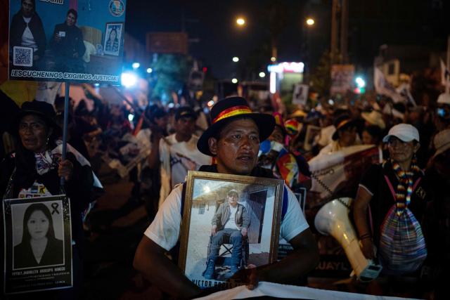 Demonstrators hold pictures of victims as they take part in a protest march called by Generation Z demanding the resignation of President Jeri in Lima on January 28, 2026. Peru's interim president, Jose Jeri, said on January 21 that he is the victim of a plot to force his resignation, in an appearance before a congressional committee investigating him for alleged influence peddling over a secret meeting with a Chinese businessman. (Photo by Ernesto BENAVIDES / AFP)