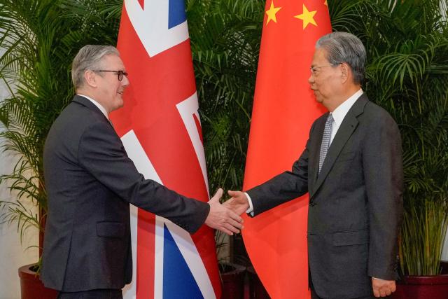 Zhao Leji (R), Chairman of the Standing Committee of China’s National People’s Congress (NPC), shakes hands with Britain's Prime Minister Keir Starmer at the Great Hall of the People in Beijing on January 29, 2026. Starmer arrived on January 28 for the first visit by a British prime minister to China since 2018, seeking to promote what he called "pragmatic" partnership with the Asian giant after years of fraught relations. (Photo by Kin Cheung / POOL / AFP)
