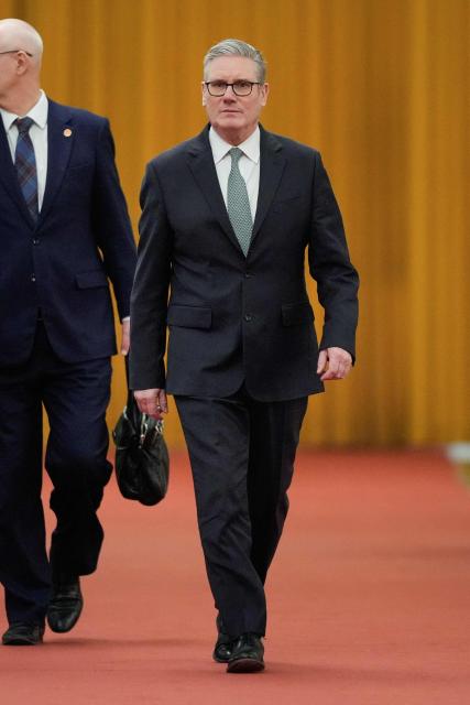 Britain's Prime Minister Keir Starmer (R) walks to his meeting with China's President Xi Jinping at the Great Hall of the People in Beijing on January 29, 2026. Starmer met with China's leader Xi Jinping in Beijing on January 29, state news agency Xinhua reported, with talks expected to  cover trade ties, national security and human rights. (Photo by Vincent Thian / POOL / AFP)