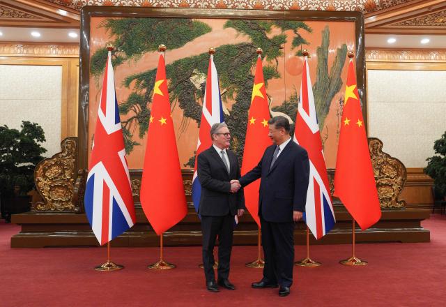 China's President Xi Jinping (R) and Britain's Prime Minister Keir Starmer shake hands before their meeting at the Great Hall of the People in Beijing on January 29, 2026. China's President Xi Jinping told Britain's Prime Minister Keir Starmer their countries must "strengthen" ties to counter geopolitical headwinds, as the leaders met in Beijing on January 29. (Photo by Carl Court / POOL / AFP)