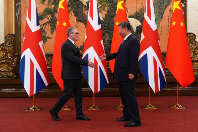China's President Xi Jinping (R) and Britain's Prime Minister Keir Starmer shake hands before their meeting at the Great Hall of the People in Beijing on January 29, 2026. China's President Xi Jinping told Britain's Prime Minister Keir Starmer their countries must "strengthen" ties to counter geopolitical headwinds, as the leaders met in Beijing on January 29. (Photo by Carl Court / POOL / AFP)