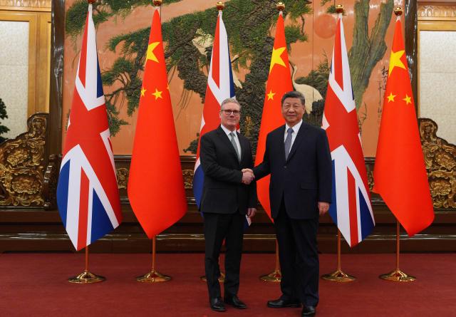 TOPSHOT - China's President Xi Jinping (R) and Britain's Prime Minister Keir Starmer shake hands before their meeting at the Great Hall of the People in Beijing on January 29, 2026. China's President Xi Jinping told Britain's Prime Minister Keir Starmer their countries must "strengthen" ties to counter geopolitical headwinds, as the leaders met in Beijing on January 29. (Photo by Carl Court / POOL / AFP)