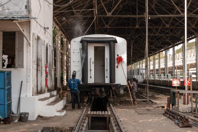 Workers clean a train carriage at Yangon Central Station in Yangon on January 28, 2026. Yangon’s Circular Railway is a 45.9 km commuter rail loop with 39 stations that connects the city center to its suburbs. Built by the British in the 1930’s, it remains one of the cheapest and most used transport options for local commuters, with a complete circuit taking about three hours to travel. (Photo by ANTHONY WALLACE / AFP)