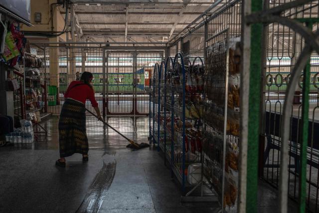 A woman mops the floor near a train platform at Yangon Central Station in Yangon on January 28, 2026. Yangon’s Circular Railway is a 45.9 km commuter rail loop with 39 stations that connects the city center to its suburbs. Built by the British in the 1930’s, it remains one of the cheapest and most used transport options for local commuters, with a complete circuit taking about three hours to travel. (Photo by ANTHONY WALLACE / AFP)