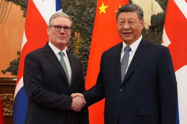 China's President Xi Jinping (R) and Britain's Prime Minister Keir Starmer shake hands before their meeting at the Great Hall of the People in Beijing on January 29, 2026. Xi told Starmer their countries must "strengthen" ties to counter geopolitical headwinds, as the leaders met in Beijing on January 29. (Photo by Carl Court / POOL / AFP)