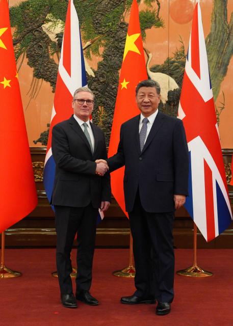 China's President Xi Jinping (R) and Britain's Prime Minister Keir Starmer shake hands before their meeting at the Great Hall of the People in Beijing on January 29, 2026. Xi told Starmer their countries must "strengthen" ties to counter geopolitical headwinds, as the leaders met in Beijing on January 29. (Photo by Carl Court / POOL / AFP)