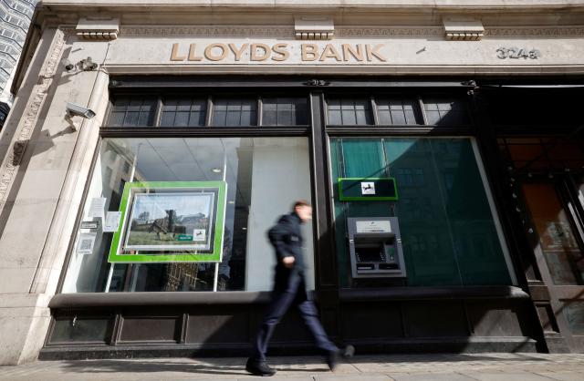 (FILES) A pedestrian walks past a branch of a Lloyds Bank in London on February 24, 2021. Britain's Lloyds Banking Group on January 29, 2026 said its net profit rose six percent in 2025 as higher income offset compensation for consumers caught up in a UK car loans scandal. (Photo by Tolga Akmen / AFP)