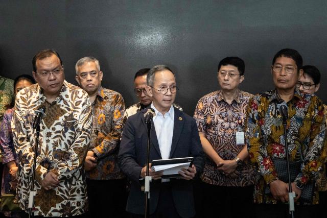 Mahendra Siregar (C), Chairman of the Board of Commissioners of the Indonesian Financial Services Authority (OJK), speaks to the media at the Indonesia Stock Exchange (IDX) in Jakarta on January 29, 2026. (Photo by YASUYOSHI CHIBA / AFP)