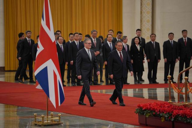 Chinese Premier Li Qiang (R) and Britain's Prime Minister Keir Starmer attend a welcome ceremony at the Great Hall of the People in Beijing on January 29, 2026. Chinese President Xi Jinping told Starmer their countries must "strengthen" ties to counter geopolitical headwinds, as the leaders met in Beijing on January 29. (Photo by Kin Cheung / POOL / AFP)