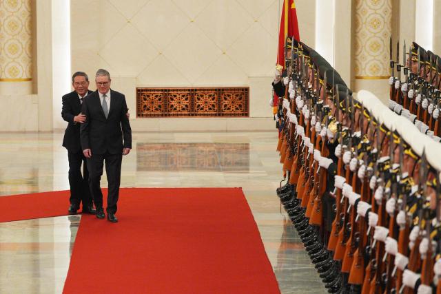 Chinese Premier Li Qiang (L) and Britain's Prime Minister Keir Starmer inspect a Chinese honour guard during a welcome ceremony at the Great Hall of the People in Beijing on January 29, 2026. Chinese President Xi Jinping told Starmer their countries must "strengthen" ties to counter geopolitical headwinds, as the leaders met in Beijing on January 29. (Photo by Carl Court / POOL / AFP)
