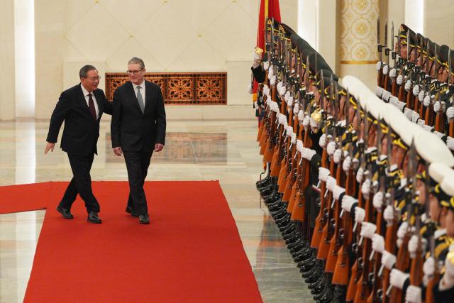Chinese Premier Li Qiang (L) and Britain's Prime Minister Keir Starmer inspect a Chinese honour guard during a welcome ceremony at the Great Hall of the People in Beijing on January 29, 2026. Chinese President Xi Jinping told Starmer their countries must "strengthen" ties to counter geopolitical headwinds, as the leaders met in Beijing on January 29. (Photo by Carl Court / POOL / AFP)