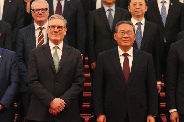 British Prime Minister Keir Starmer (L) and Chinese Premier Li Qiang pose with their business delegations at the Great Hall of the People in Beijing on January 29, 2026. Chinese President Xi Jinping told Starmer their countries must "strengthen" ties to counter geopolitical headwinds, as the leaders met in Beijing on January 29. (Photo by Carl Court / POOL / AFP)