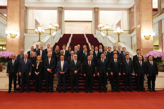 British Prime Minister Keir Starmer (c-L) and Chinese Premier Li Qiang (C-R) pose with their business delegations at the Great Hall of the People in Beijing on January 29, 2026. Chinese President Xi Jinping told Starmer their countries must "strengthen" ties to counter geopolitical headwinds, as the leaders met in Beijing on January 29. (Photo by Carl Court / POOL / AFP)